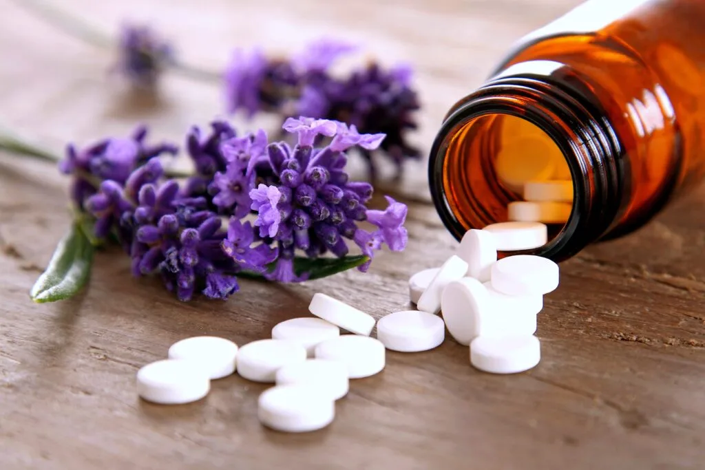 Homeopathic globules spilling from an amber glass bottle, illustrating the classical homeopathy and naturopathic remedies available at Diana Apotheke.