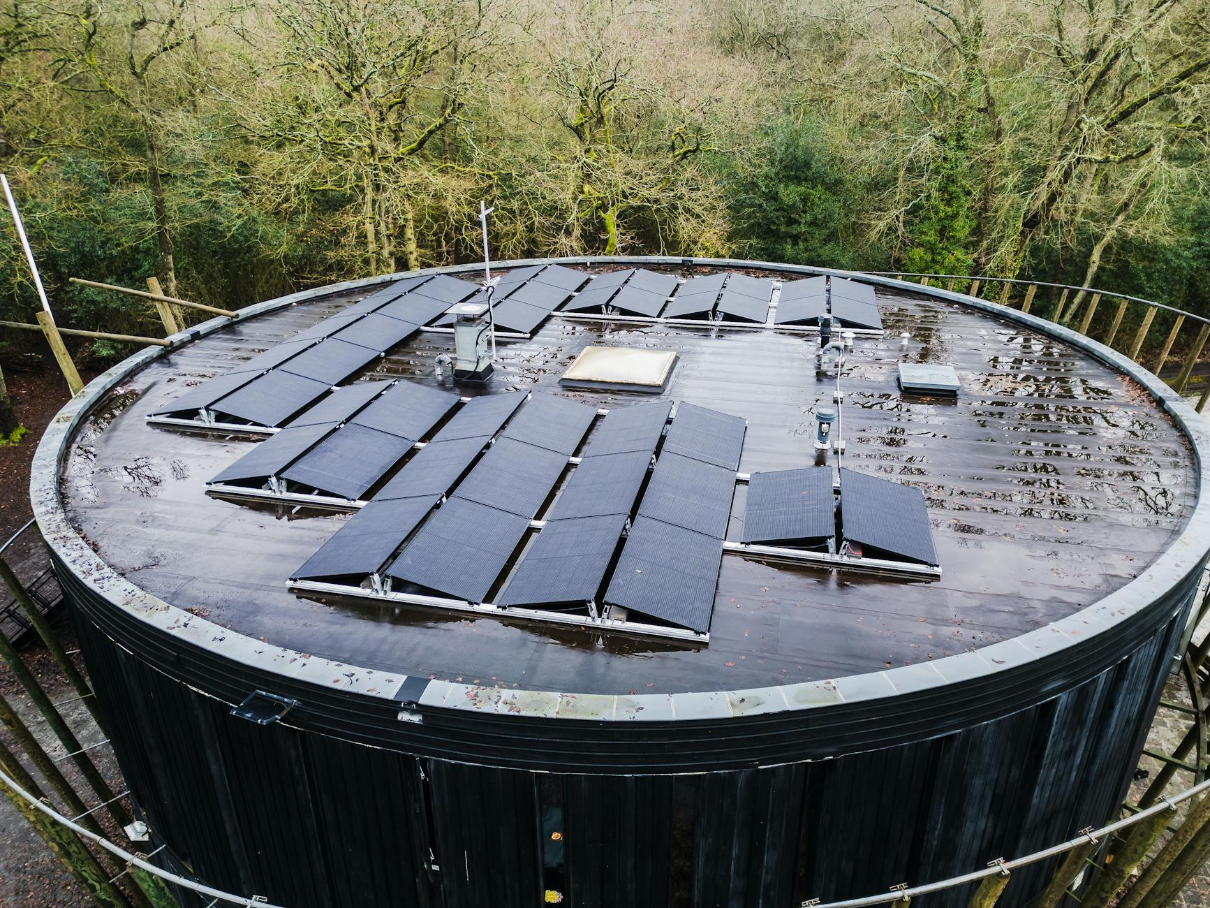 Eine moderne, nachhaltige Therme in Österreich mit begrünten Dächern und Solaranlagen, umgeben von natürlicher Landschaft, die Wellness und Umweltschutz verbindet.